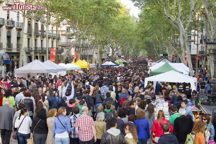 Immagine La Rambla durante il giorno di San Giorgio a Barcellona, Spagna. Turisti e residenti a passeggio ne La Rambla, il suggestivo viale cittadino che collega Placa de Catalunya con il porto vecchio. Lungo questa strada, che si estende per 1 chilometro e 400 metri, si affollano stand e bancarelle per la vendita di fiori e libri: è il 23 Aprile, giorno di San Giorgio - © Natursports / Shutterstock.com