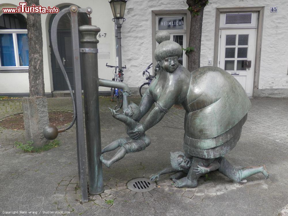 Immagine La simpatica statua di una donna che lava il suo bambino sotto una fontana a Osnabruck, Bassa Sassonia, Germania  - © Hans wrang / Shutterstock.com