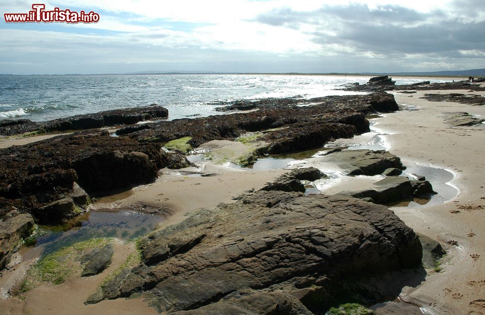 Immagine La spiaggia di Dornoch con la bassa marea, Scozia. Grazie al fenomeno dell'abbassamento delle acque le rocce affiorano in superficie.