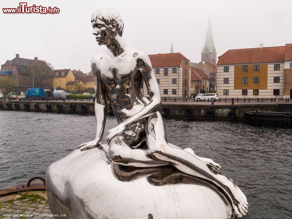 Immagine La statua del Little Merman aka Han a Helsingor, Danimarca, sul lungomare. E' stata installata lungo i vecchi cantieri navali della città e rappresenta la figura di un principe che imita nella posa la nota Sirenetta. E' in acciaio inox - © Arndale / Shutterstock.com