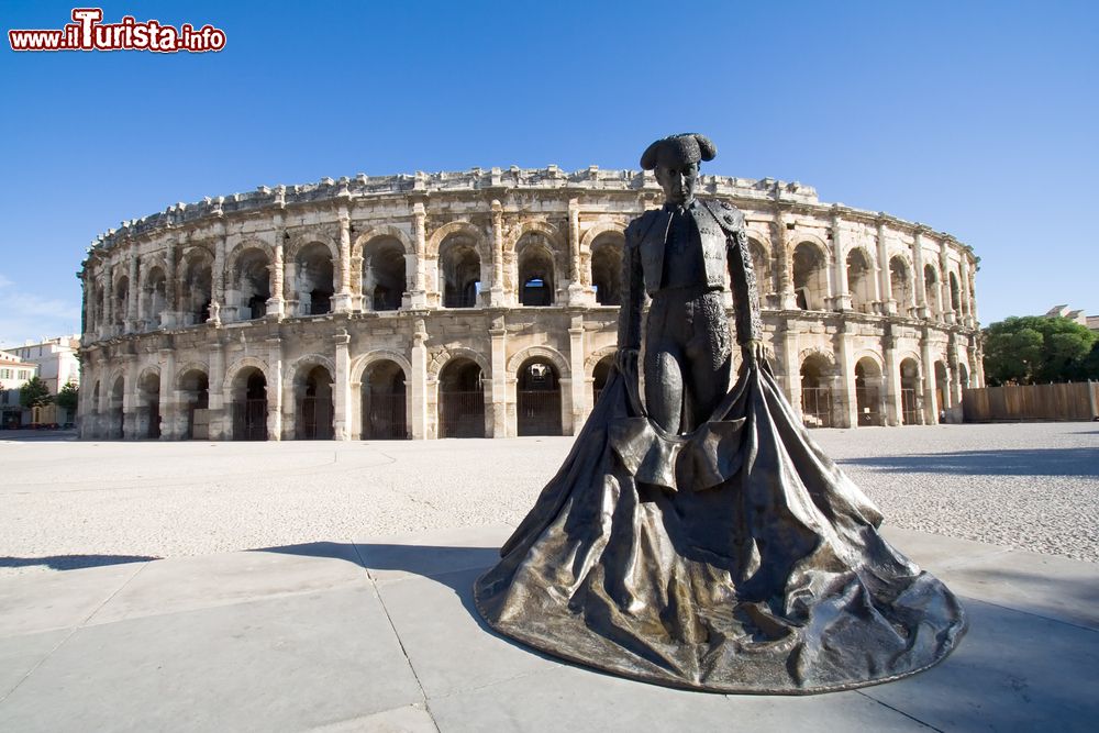 Immagine La statua del torero con l'arena sullo sfondo, simboli della cittadina di Nimes (Francia).