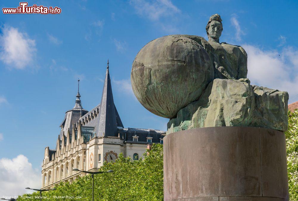Immagine La statua di un uomo che sorregge il mondo nella cittadina di Chartres, Francia. Sullo sfondo, la bilbioteca pubblica - © Michael Warwick / Shutterstock.com