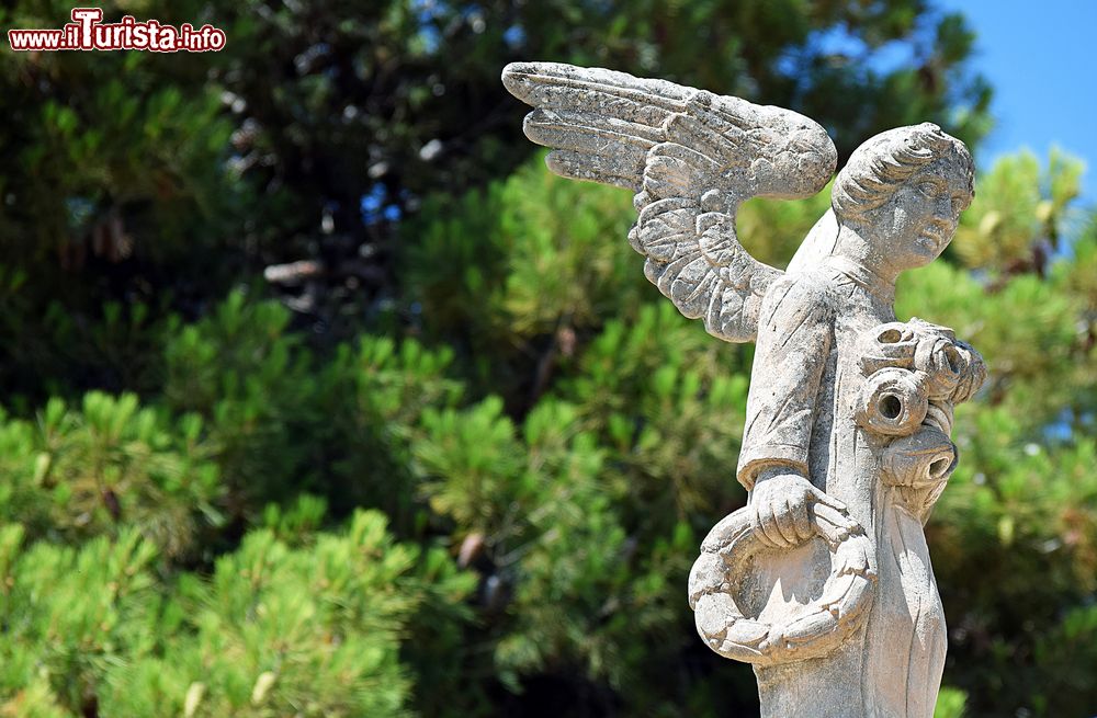 Immagine La statua in pietra di un angelo con un anello di pane in mano a Avola, Sicilia.