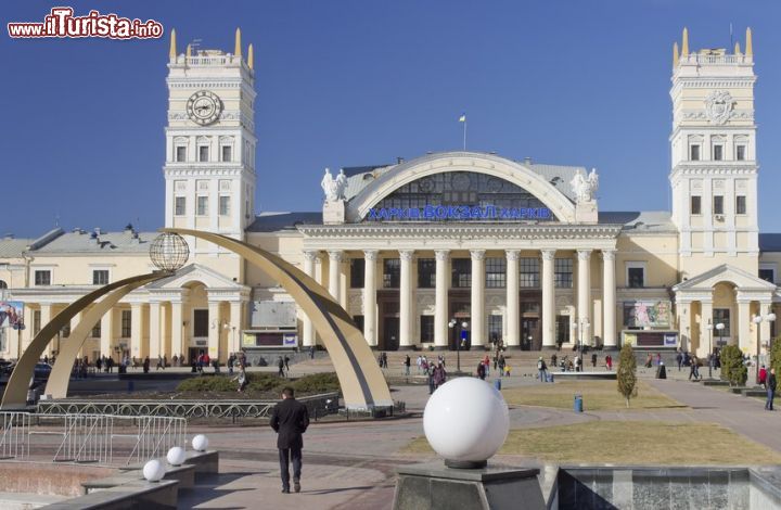 Immagine La stazione ferroviaria e Piazza della Stazione a Kharkiv, Ucraina. Palazzi maestosi, fontane e aiuole impreziosiscono l'area che ospita la stazione cittadina. L'edificio principale è costituito da due torri unite da una bella cupola decorata con una fusione in bronzo e ceramica - © vosilich / Shutterstock.com