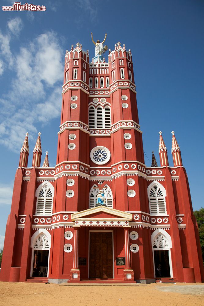 Immagine La suggestiva cattedrale di San Giuseppe a Trivandrum, Kerala, India. La facciata color rosso mattone è impreziosita da dettagli bianchi e dalla grande statua di Cristo che troneggia sulla sommità fra le due torri.