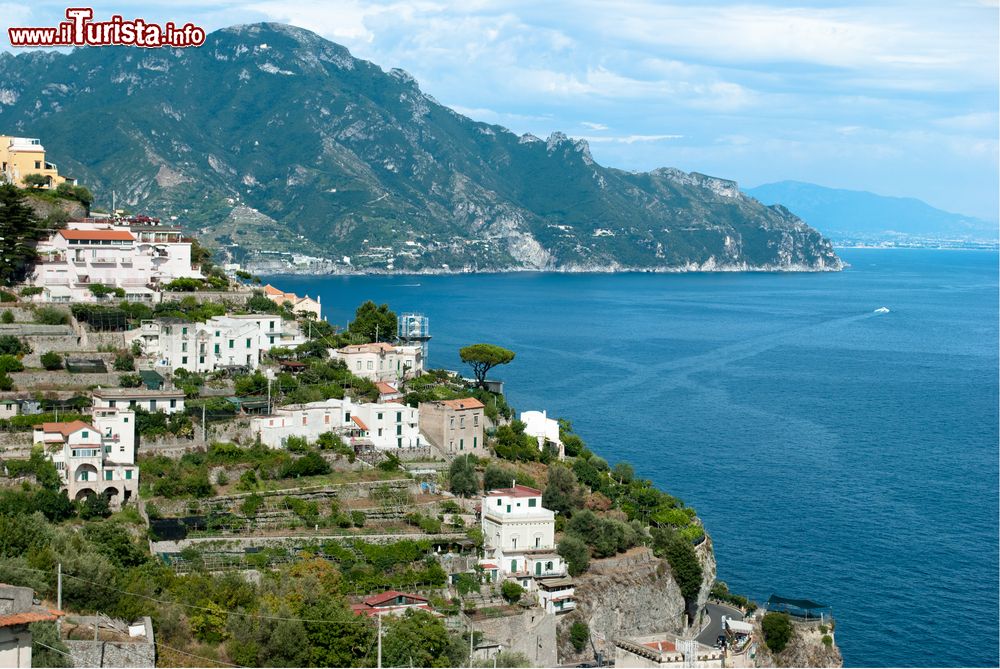 Immagine La suggestiva Costiera Amalfitana fotografata da Conca dei Marini, Campania. Si snoda per circa 50 chilometri a sud della Penisola Sorrentina ed è caratterizzata da scogliere ripide e da una costa frastagliata costellata di spiaggette e villaggi di pescatori.