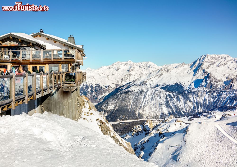 Immagine La terrazza di un ristorante in cima alla stazione sciistica di Courchevel (Francia) con le piste innevate.