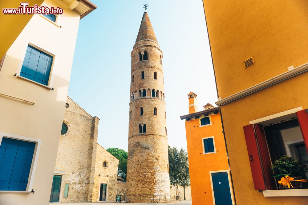 Immagine La torre del Duomo di Santo Stefano sul lungomare di Caorle, Veneto. A forma cilindrica, è sormontato da una cuspide conica in stile romanico.