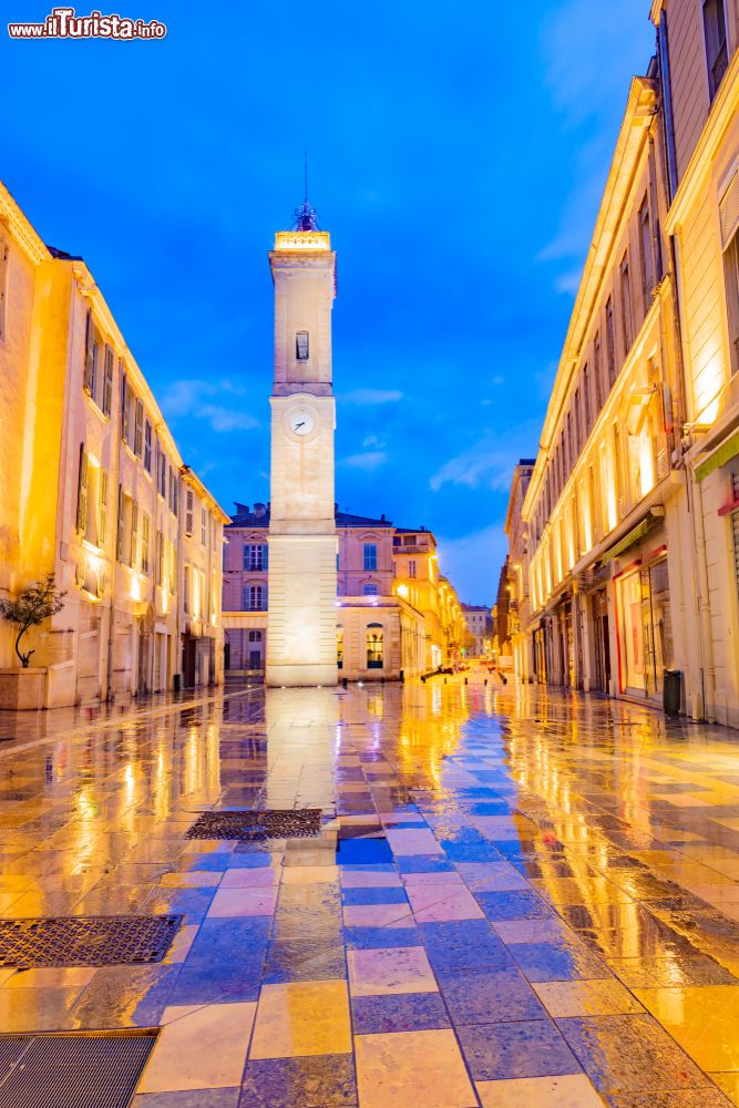 Immagine La torre dell'orologio di Nimes nell'omonima piazza illuminata di sera, Francia.