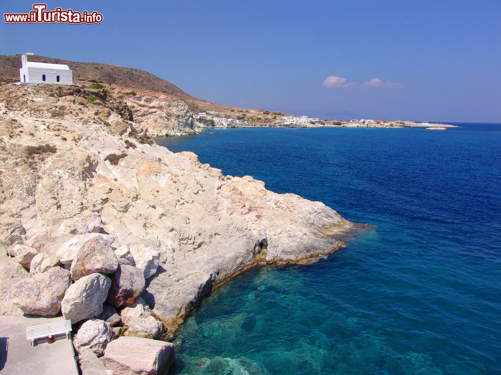 Immagine L'acqua blu del Mare Egeo lambisce la costa rocciosa dell'isoletta di Kimolos, Grecia.