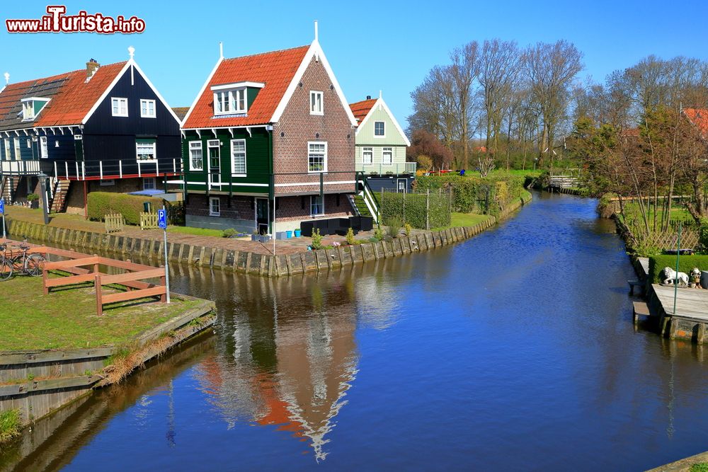 Immagine L'acqua di un canale con i riflessi dei tipici edifici in legno a Marken, Olanda - © Inu / Shutterstock.com