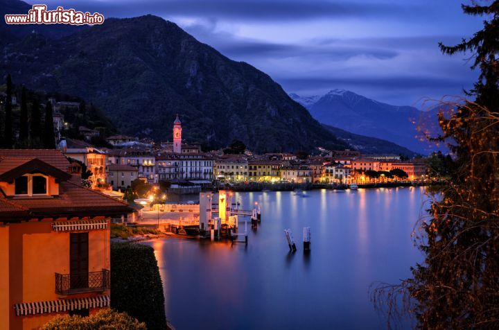 Immagine Lago di Como a Menaggio by night, Lombardia. Le luci di abitazioni e palazzi si riflettono sulle acque del Lario creando un'atmosfera ancora più incantevole in questo grazioso angolo di Lombardia - © Marco Saracco / Shutterstock.com