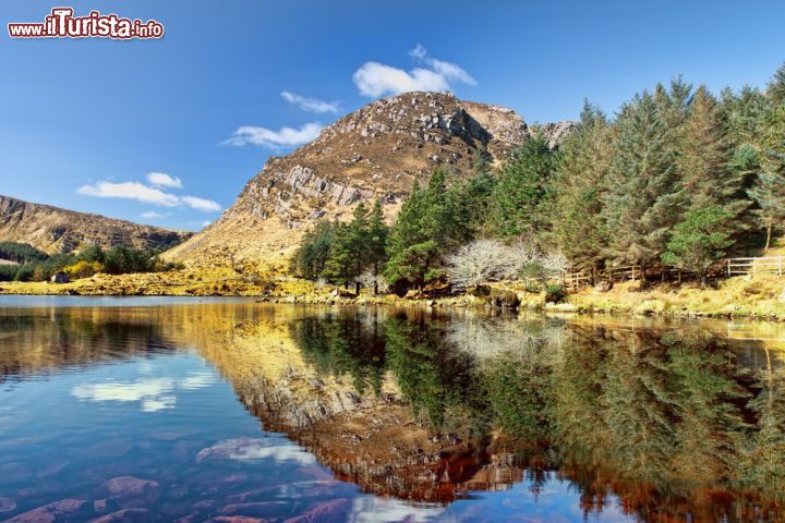 Immagine Lago fra le montagne nella penisola di Dingle, Irlanda. La vegetazione si rispecchia nelle acque limpide e cristalline di questo bacino montano: la penisola è uno dei luoghi più turistici del paese grazie ai suoi suggestivi paesaggi naturalistici - © Lukasz Pajor / Shutterstock.com