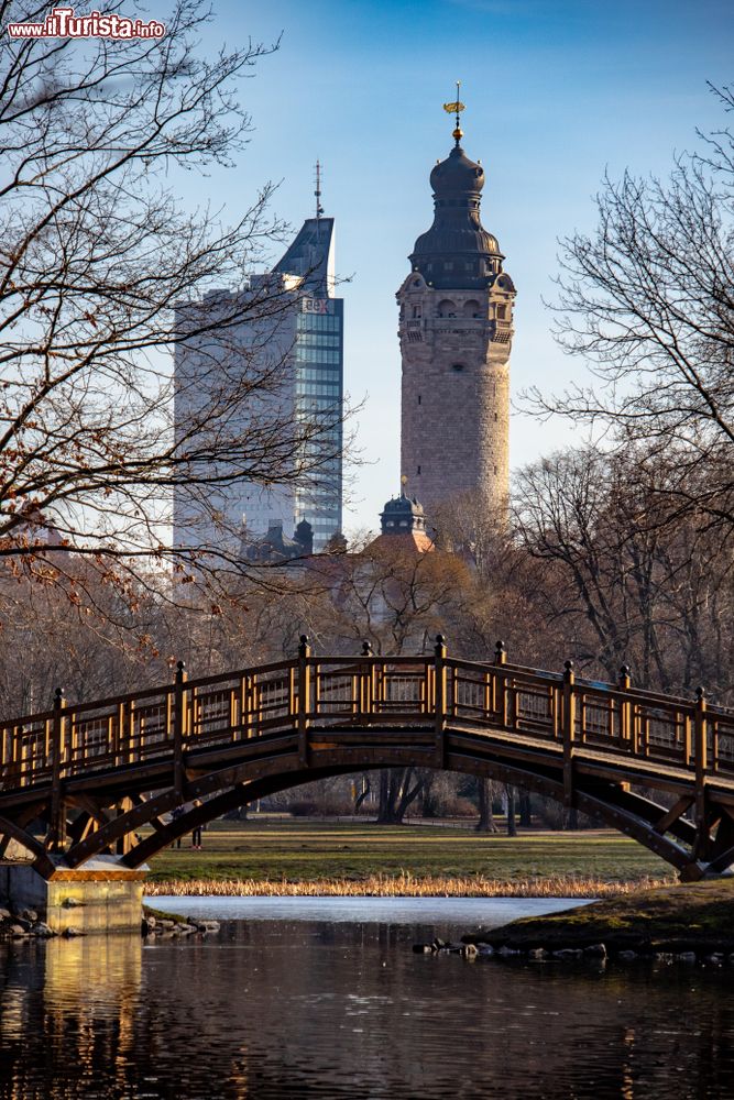 Immagine Landscape di Lipsia con stagno, ponte e alberi (Germania): sullo sfondo, il Municipio e un grattacielo.