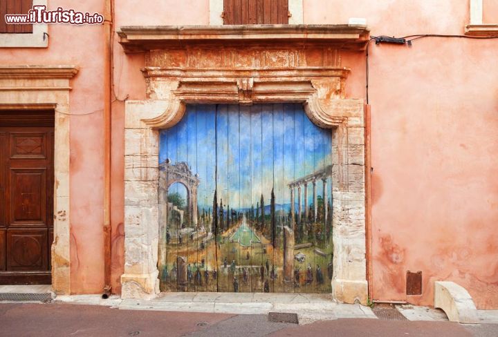 Immagine Le case di Roussillon, nel sud della Francia, sono sempre molto curate. Oltre al colore degli edifici, tipicamente rossastro a causa dell'ocra, anche le porte, le finestre e i balconi fioriti contribuiscono a creare un'atmosfera suggestiva -  © Olgysha / Shutterstock.com