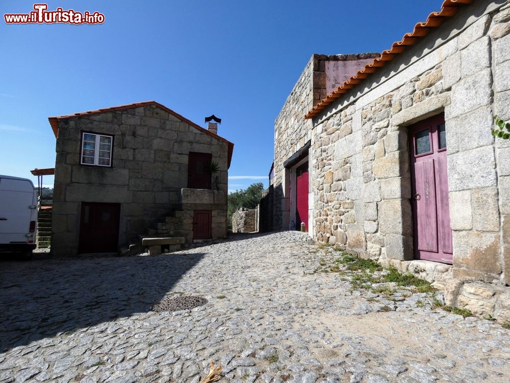 Immagine Le case in pietra del villaggio di Marialva, Portogallo, in una giornata con il cielo blu.