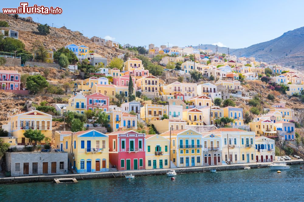 Immagine Le case variopinte nel porto di Symi, isola di Symi, Grecia. Ottava isola più grande del Dodecaneso, Symi è caratteristica per le sue case costruite sulle pendici: sono in stile neoclassico a colori vivaci.