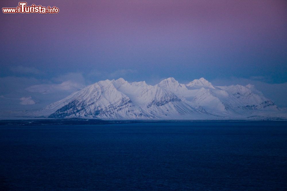 Immagine Le montagne innevate delle isole Svalbard al crepuscolo, Norvegia. Situate nel mare Glaciale Artico, queste terre sono la parte più settentrionale della Norvegia e quelle abitate più a nord del pianeta.