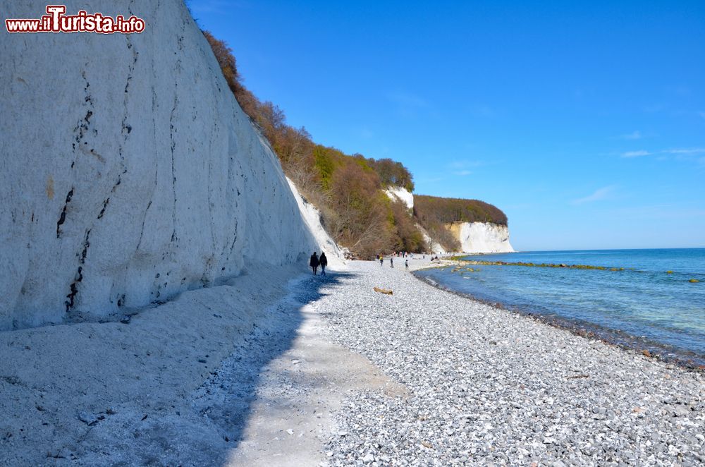 Immagine Le scogliere bianche sull'isola di Ruegen nel land tedesco del Meclemburgo-Pomerania: due persone passeggiano sul lungomare roccioso in una giornata di primavera.