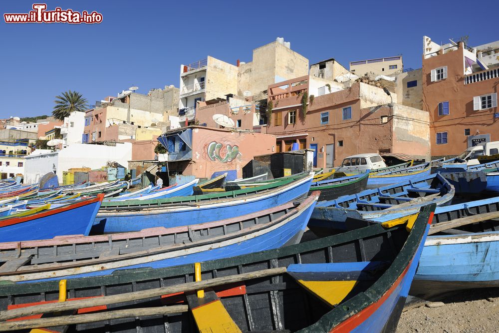 Immagine Le tipiche barche da pesca ormeggiate sulla spiaggia di Taghazout, Marocco. Dipinte spesso nelle tonalità del blu e dell'azzurro, le barchette in legno dei pescatori di Taghazout rientrano dalla giornata di lavoro con frutti di mare e pesce di ogni varietà.