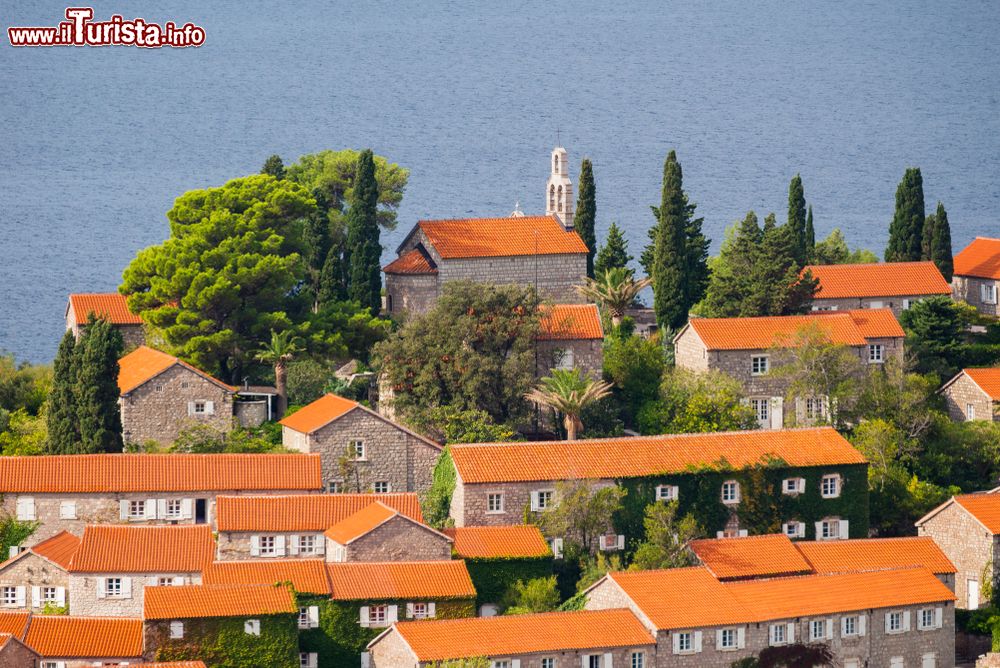 Immagine Le tradizionali case di Sveti Stefan, Montenegro. Sullo sfondo, una chiesa con campanile. Oggi è un resort  a 5 stelle sulla costa adriatica del Montenegro.