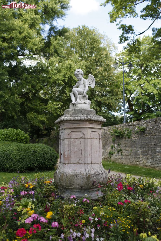 Immagine Lo scorcio di un giardino fiorito con la statua di un angelo a Beaune, Francia.