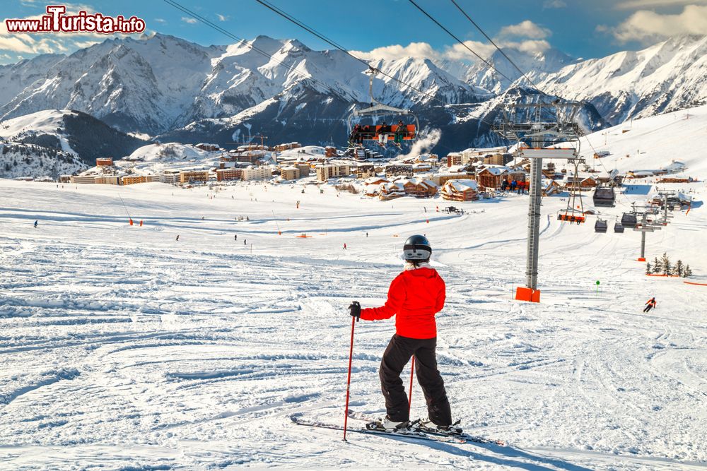 Immagine Lo ski resort dell'Alpe d'Huez, Francia, in inverno con la neve. In primo piano, uno sciatore pronto ad affrontare le piste innevate.