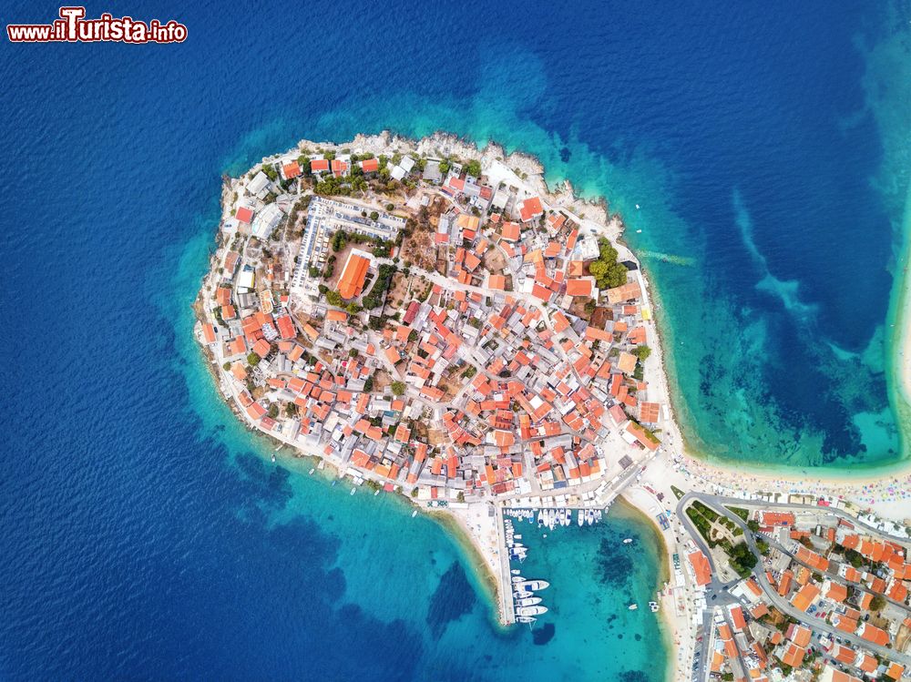 Immagine Lo splendido centro storico di Primosten, Croazia, fotografato dall'alto. Un tempo isola protetta dalle mura e dalle torri di pietra, è divenuta poi una penisola: nel XVI° secolo era un ponte mobile a collegare il villaggio con la terraferma, in seguito è stato creato un terrapieno.