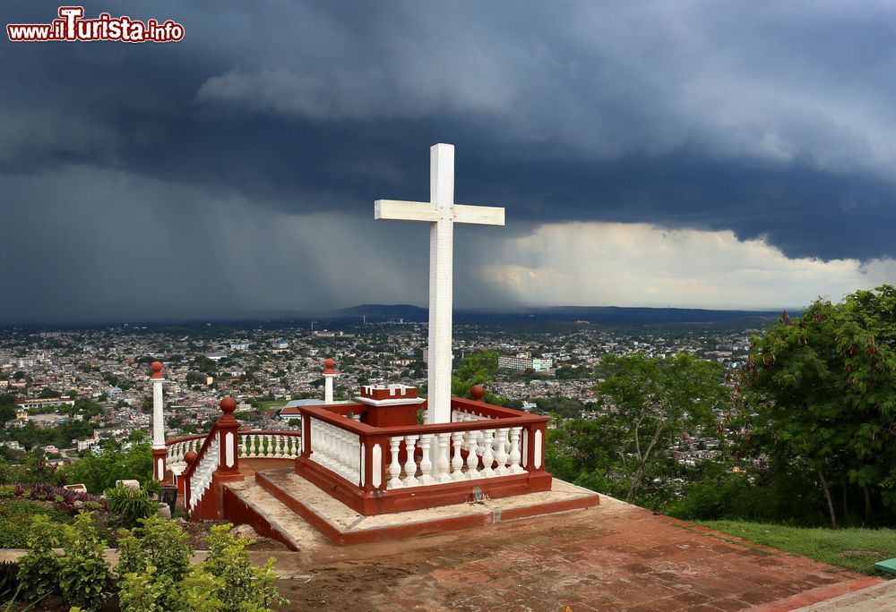 Immagine Loma de la Cruz a Holguin, Cuba. Un cielo grigio e cupo sovrasta la Hill of the Cross dove è stata innalzata una croce in legno. Si tratta di uno dei luoghi simbolo della città cubana.