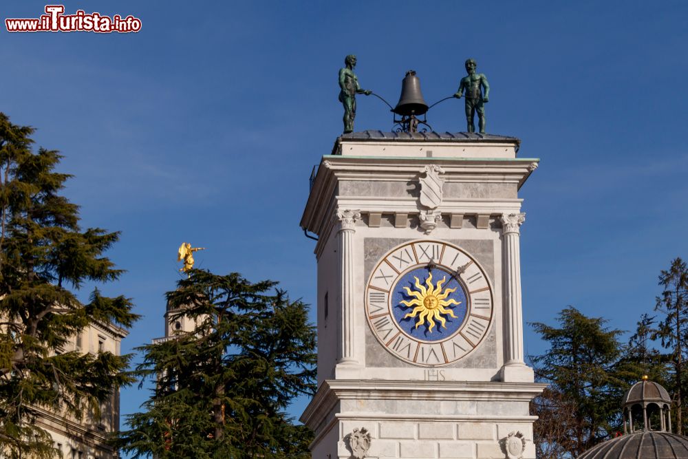 Immagine L'orologio della torre in piazza Libertà a Udine, Friuli Venezia Giulia. Sullo sfondo, l'angelo d'oro del campanile cittadino.