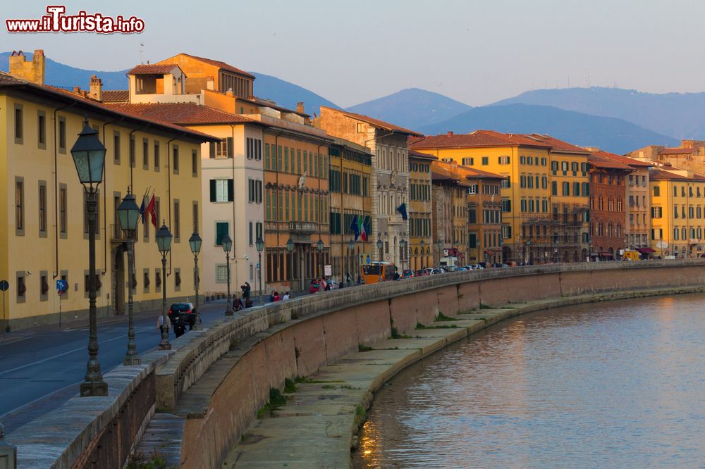 Immagine Lungofiume di Pisa alla sera, Toscana. Secondo una leggenda, la città di Pisa sarebbe stata fondata da alcuni profughi troiani provenienti dall'omonima cittadina greca.