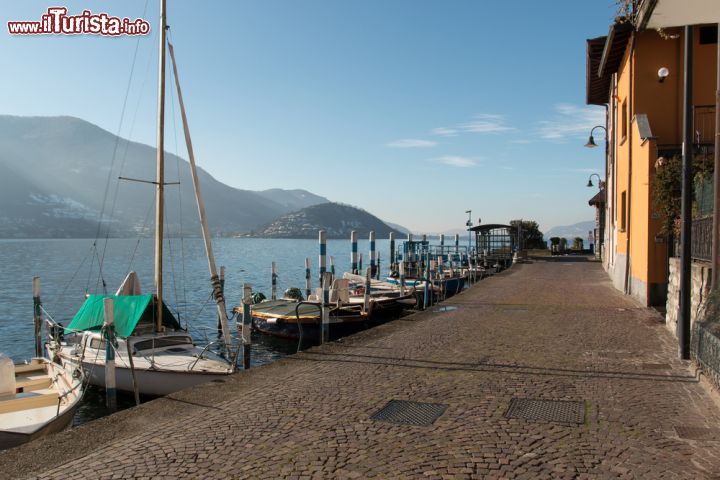Immagine Lungolago di Peschiera Maraglio, Lago d'Iseo. Ancora oggi in questo borgo, uno dei più belli d'Italia, si possono assaporare le tradizioni legate al passato, soprattutto quelle legate alla storia dei pescatori, con la produzione delle reti da pesca e la costruzione delle barche da pescatore note come "naet". Proprio a Peschiera nacquero i primi retifici, alcuni dei quali sono presenti tutt'oggi, assieme a cantieri dove abili carpentieri costruiscono a mano le imbarcazioni in legno - © Zocchi Roberto / Shutterstock.com