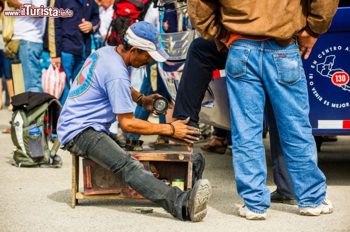 Immagine Un lustrascarpe in una strada di San José, Costa Rica. Un costaricano intento a lucidare le scarpe di un'altra persona lungo una strada della capitale  - © Anton_Ivanov / Shutterstock.com