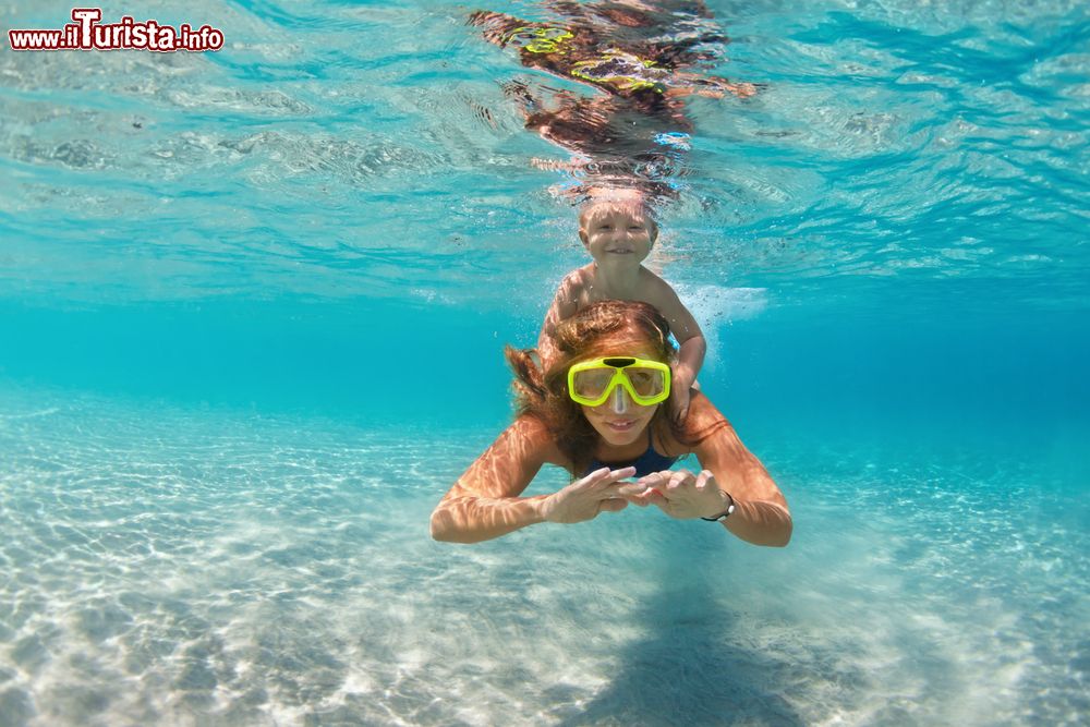 Immagine Mamma e bambino fanno snorkeling e nuotano sott'acqua nel mare a Inagua, arcipelago delle Bahamas. E' una delle tante attività sportive che si possono praticare in quest'isola circondata dall'oceano Atlantico.