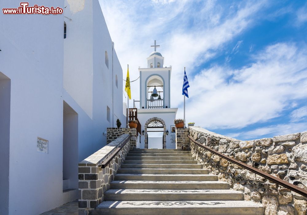 Immagine Mandraki, isola di Nisyros (Grecia): una chiesetta con a fianco la bandiera greca.