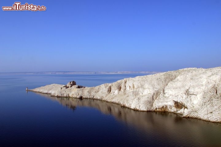 Immagine il Mare di Pag in Croazia (Pago): bianche rocce calcaree lungo la costa settentrionale della lunga isola dellla Dalmazia. Si notano le rovine di un antico faro che serviva questo tratto di costa adriatica - © Zvonimir Atletic / Shutterstock.com