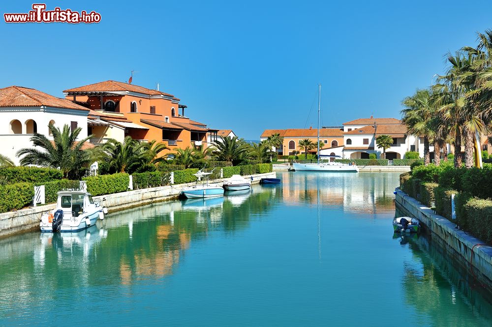 Immagine Marina di Policoro, Basilicata: barche ormeggiate e palazzi eleganti che si rispecchiano nell'acqua.