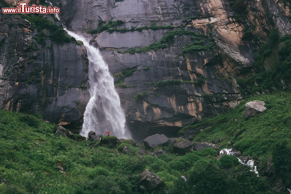 Immagine Un minuscolo viaggiatore sotto la cascata di Yogini nell'Himalaya indiano, stato dell'Himachal Pradesh.