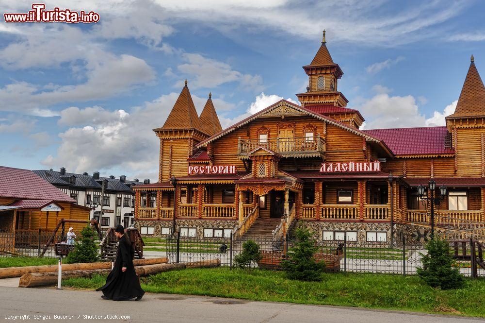 Immagine Un monaco passeggia per le vie di Tobolsk, Russia. Sullo sfondo, il ristorante Ladeyny ospitato in un edificio costruito in legno - © Sergei Butorin / Shutterstock.com