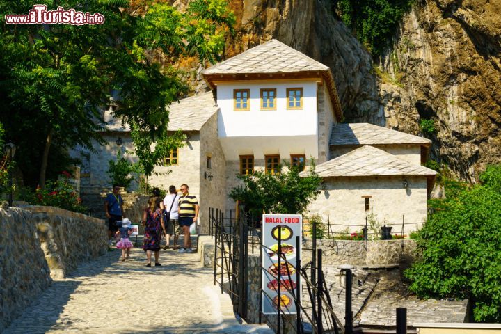 Immagine L'ingresso del Blagaj Tekija, a Blagaj - il famoso tempio derviscio di Blagaj, si staglia imponente ai piedi della montagna, in questo pittoresco villaggio nel sud della Bosnia, ormai famoso in tutta Europa. Il monastero fu costruito nel 1520 dai seguaci di questa confraternita islamica e, ad oggi, è aperto ai turisti. - © RnDmS / Shutterstock.com