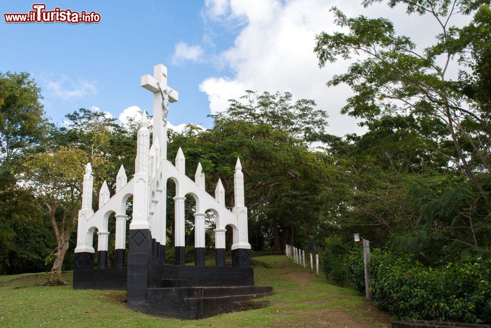 Immagine Monumento religioso a Roseau, isola di Dominica, America Centrale. Una croce con Gesù circondata dalla rigogliosa foresta dell'isola.