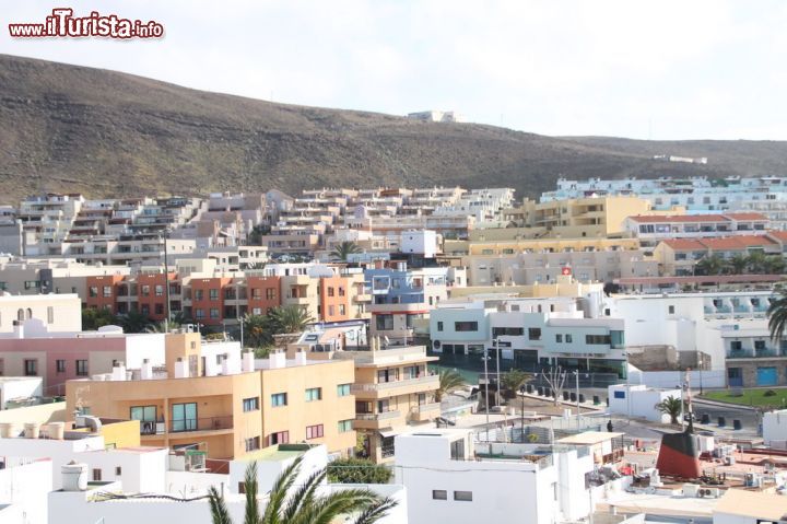 Immagine La città di Morro Jable vista dall'alto, Fuerteventura, Spagna - Si trova nella parte più meridionale delle Canarie, è dotata di moltissimi hotel e alberghi, inoltre secondo un'indagine recente sembrerebbe la località di Fuerteventura più apprezzata dai turisti. Probabilmente perché non solo le spiagge sono stupende, ma anche perché il centro urbano propone delle comodità eccellenti, una movida accesa e un arredamento edilizio sublime.