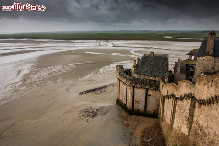 Immagine Le mura di Mont-Saint-Michel e la piana tidale con la bassa marea, Normandia, Francia - © Pocholo Calapre / Shutterstock.com