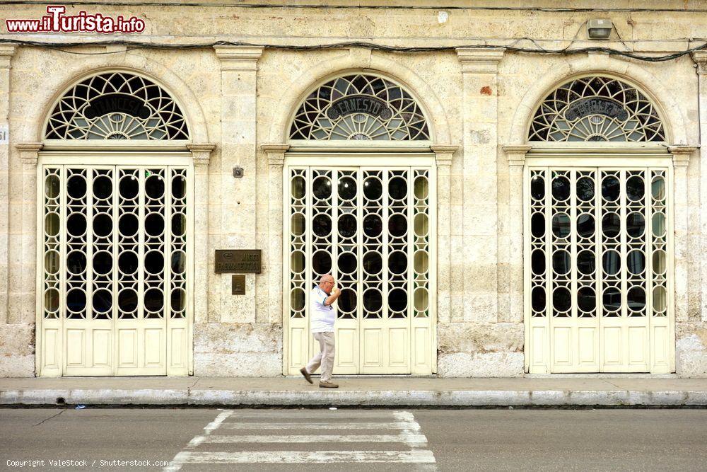 Immagine Un signore passeggia sul marciapiede di fronte al Museo Farmaceutico di Matanzas, Cuba - © ValeStock / Shutterstock.com