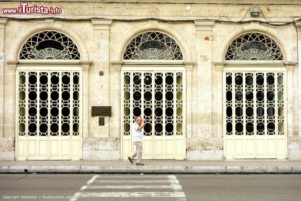 Immagine Un signore passeggia sul marciapiede di fronte al Museo Farmaceutico di Matanzas, Cuba - © ValeStock / Shutterstock.com