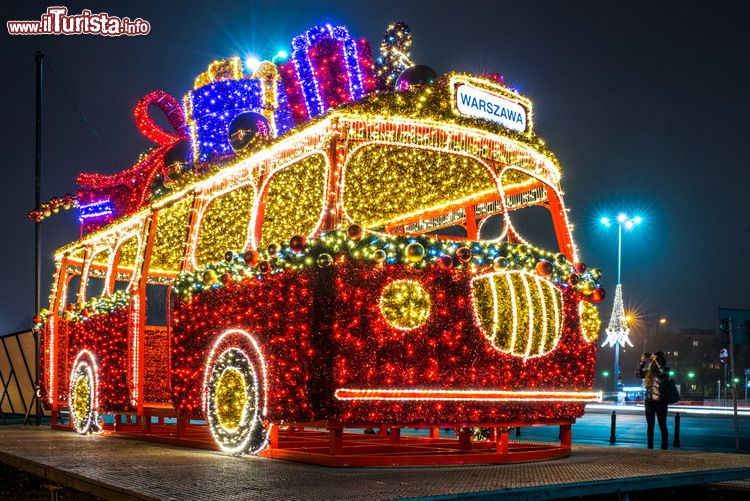 Immagine Natale a Varsavia, Polonia: illuminazione a forma di pulmino con pacchi regalo sul tetto.