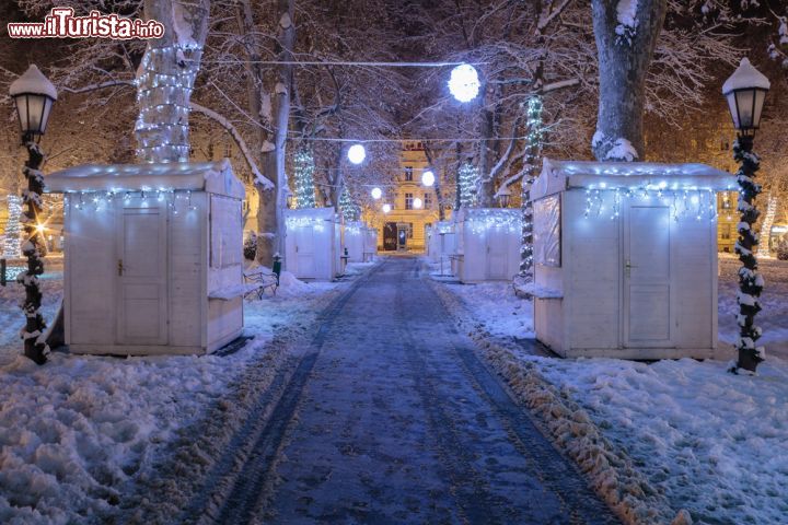 Immagine Neve al parco Zrinjevac a Zagabria, Croazia. Questa piazza giardino della capitale croata è la più conosciuta: nel XIX° secolo era un pascolo che ospitava il mercato del bestiame. Oggi invece è stata trasfromata in un lussuoso viale con platani, padiglione musicale, fontane e monumenti. In inverno qui si allestisce anche il mercatino natalizio con le graziose casette in legno dove acquistare regali e prodotti tipici - © Dario Vuksanovic / Shutterstock.com