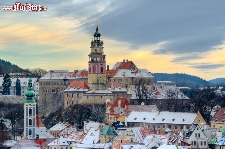 Immagine Panorama innevato del centro storico di Cesky Krumlov, Repubblica Ceca - l'opacità del cielo invernale e la neve sui tetti donano alla città un'atmosfera davvero magica, specialmente se osservati in contrasto con i colori vivaci degli edifici storici del centro e del castello medievale, la cui splendida torre assume il ruolo di assoluta protagonista nello "spettacolo" della città. - © Pavel Ilyukhin / Shutterstock.com