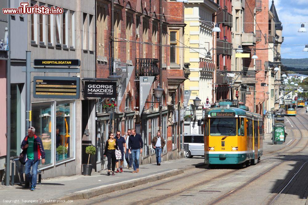 Immagine Norrkoping, una via del centro storico con gente a passeggio e un tram (Svezia) - © Tupungato / Shutterstock.com