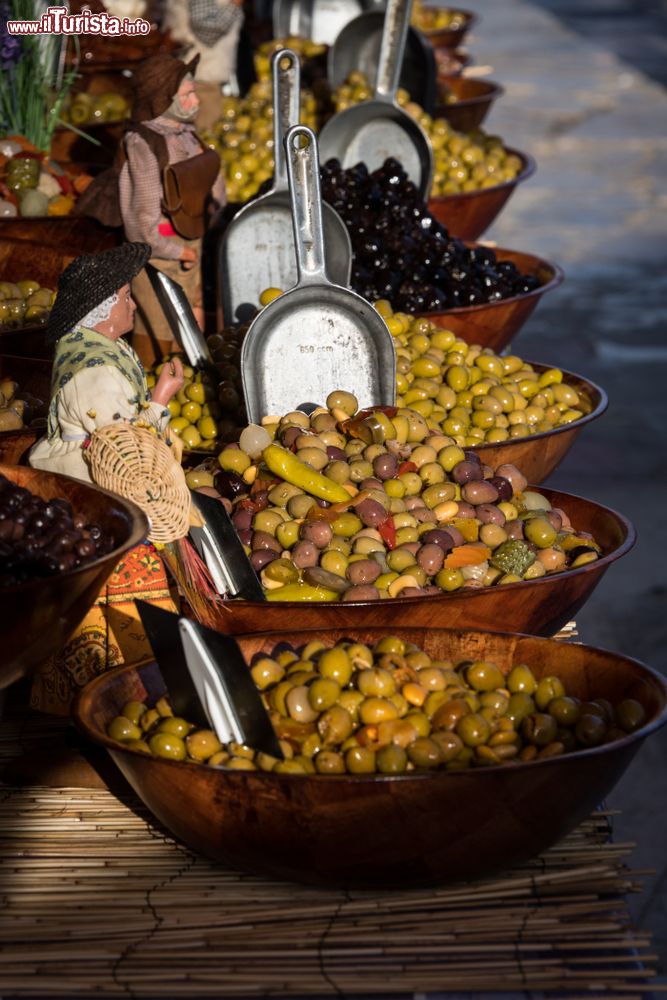 Immagine Olive in vari condimenti in vendita in un mercato di Sanary-sur-Mer, Francia.